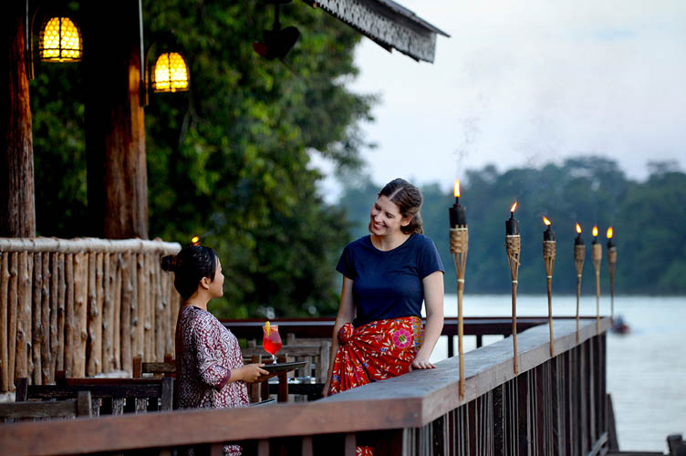 tourists interacting with a staff of Sukau Rainforest Lodge's Melapi restaurant