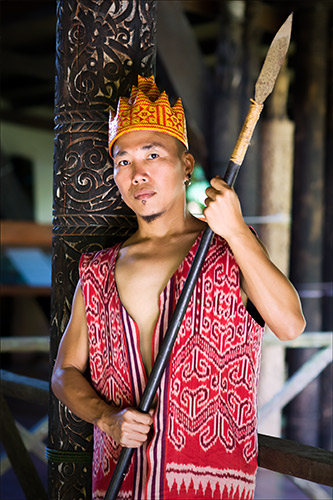 Orang Sungai warrior in traditional attire holding a spear